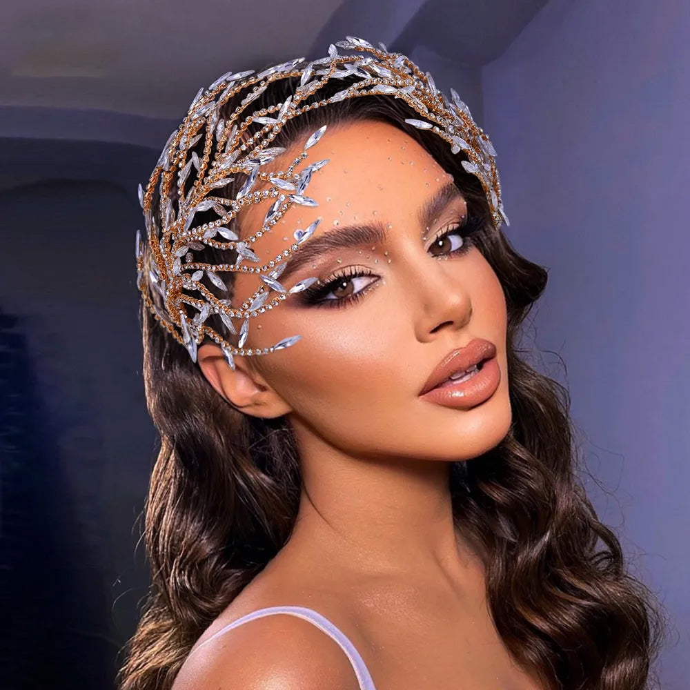 Glamour portrait profile of a woman with wavy hair wearing a multi-layered gold rhinestone bridal headpiece adorned with clear marquise crystal sprays.