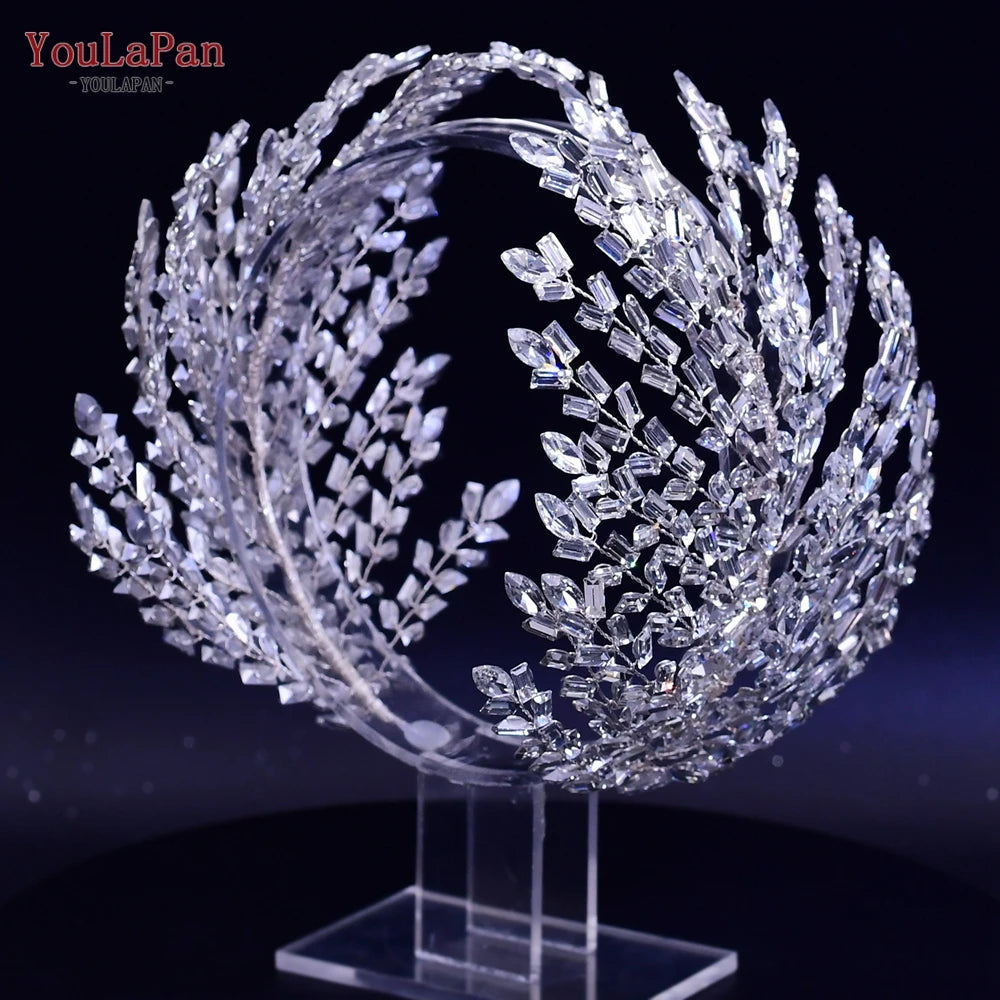 Full view of a stunning silver crystal wedding tiara showcasing large architectural spray arches, securely placed on a clear display stand.
