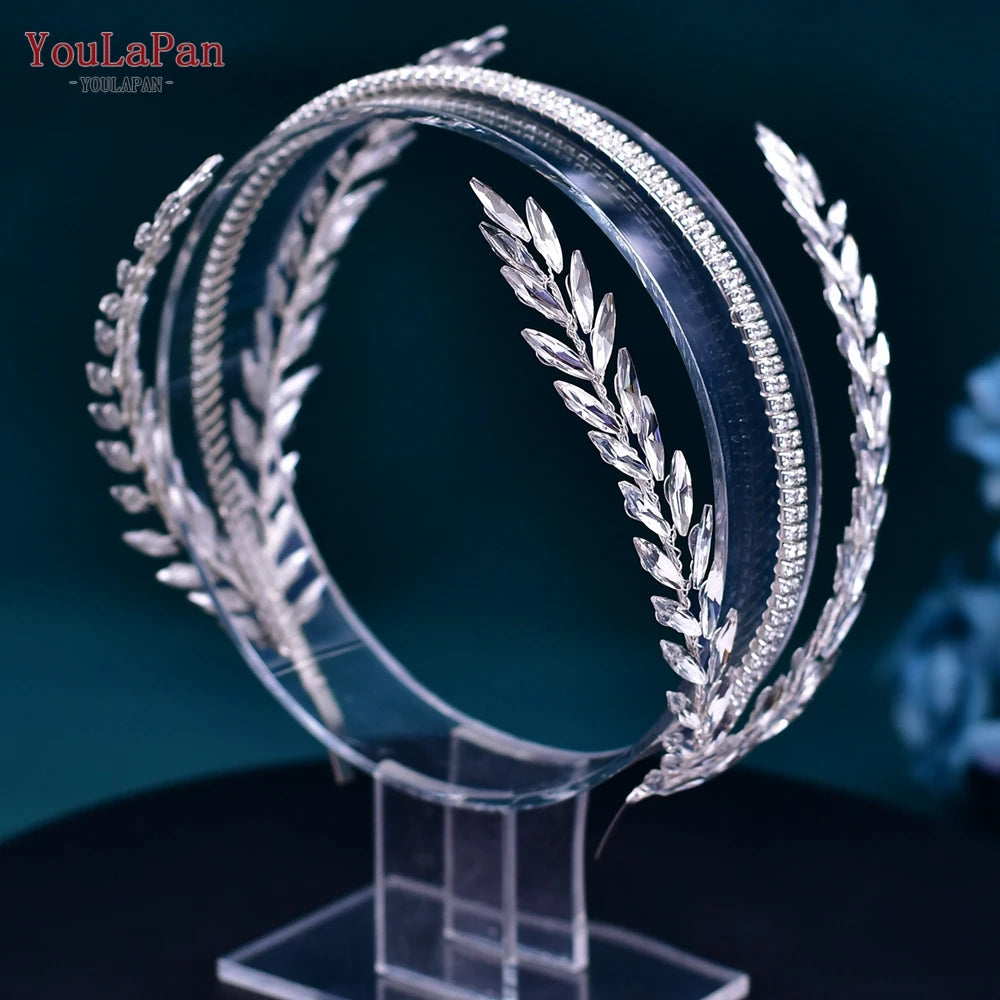 Symmetrical front profile view of an open-back silver laurel leaf style bridal crown headpiece displayed on a transparent mannequin stand.