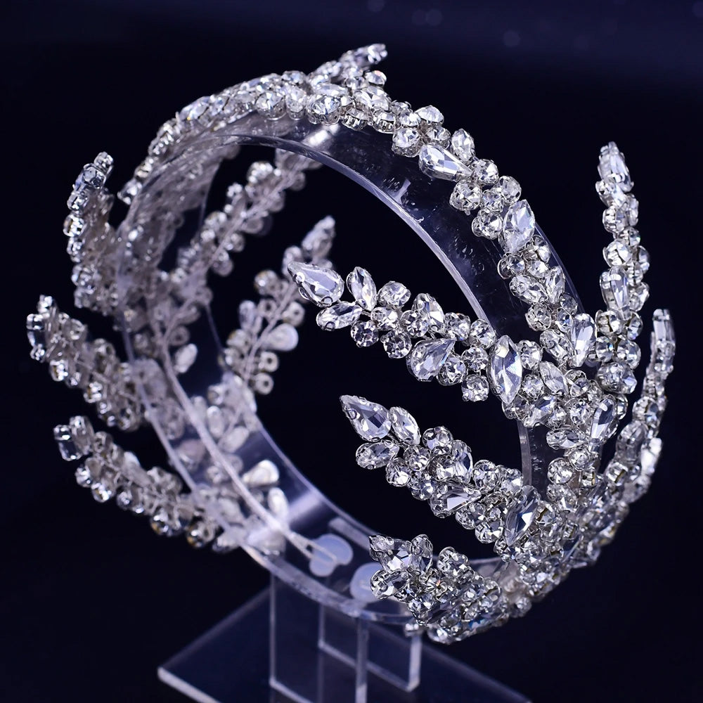 High-angle profile shot of a silver wedding hair crown tiara with multi-tiered rows of clear marquise crystals displayed on a clear stand.
