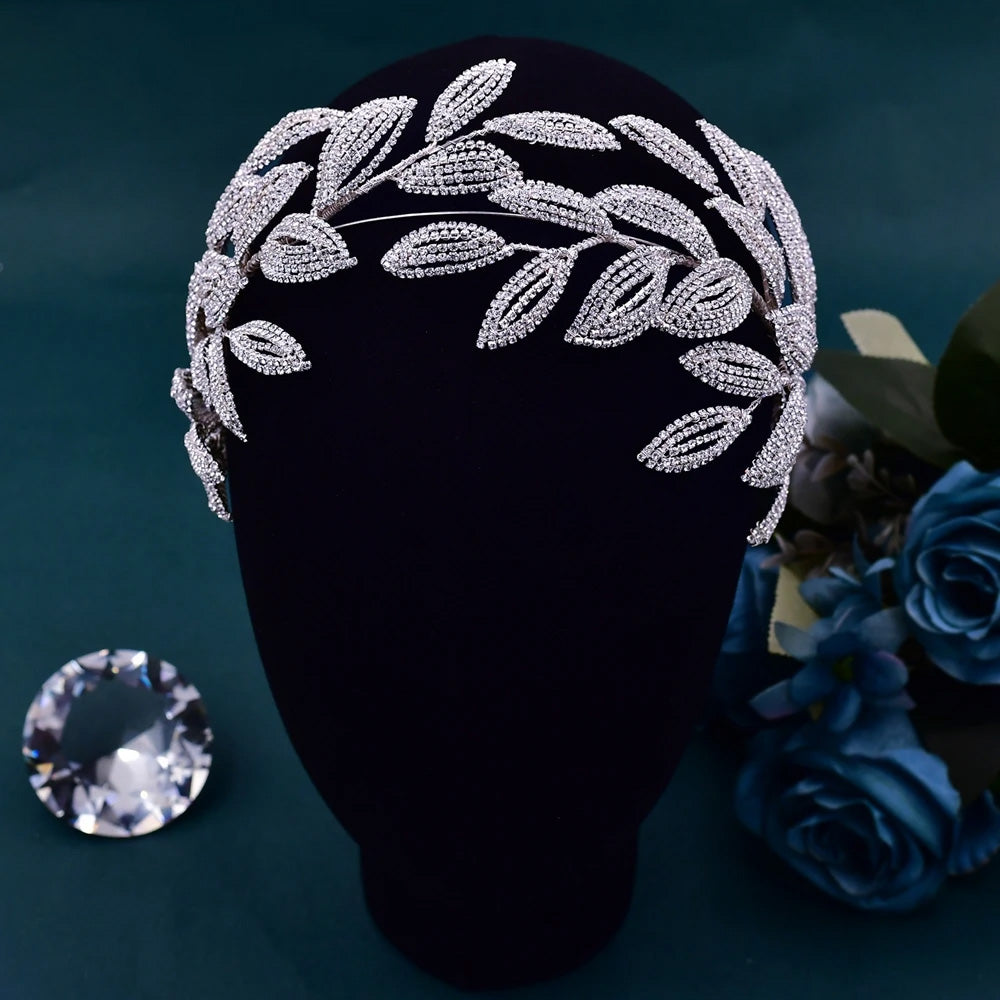 Symmetrical front profile view of an open-back silver laurel leaf style bridal crown headpiece displayed on a transparent mannequin stand.