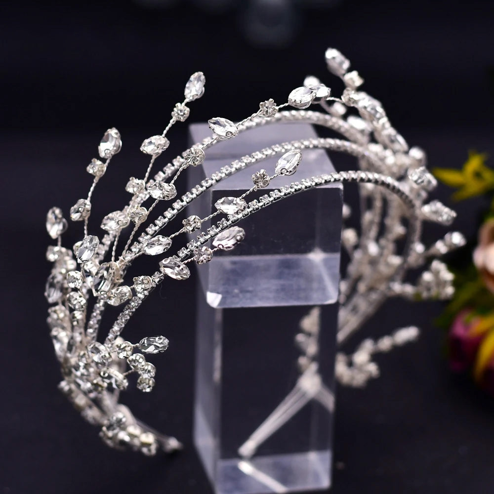Full view of a stunning multi-strand silver crystal wedding tiara showcasing delicate architectural spray arches, securely placed on a clear acrylic stand.