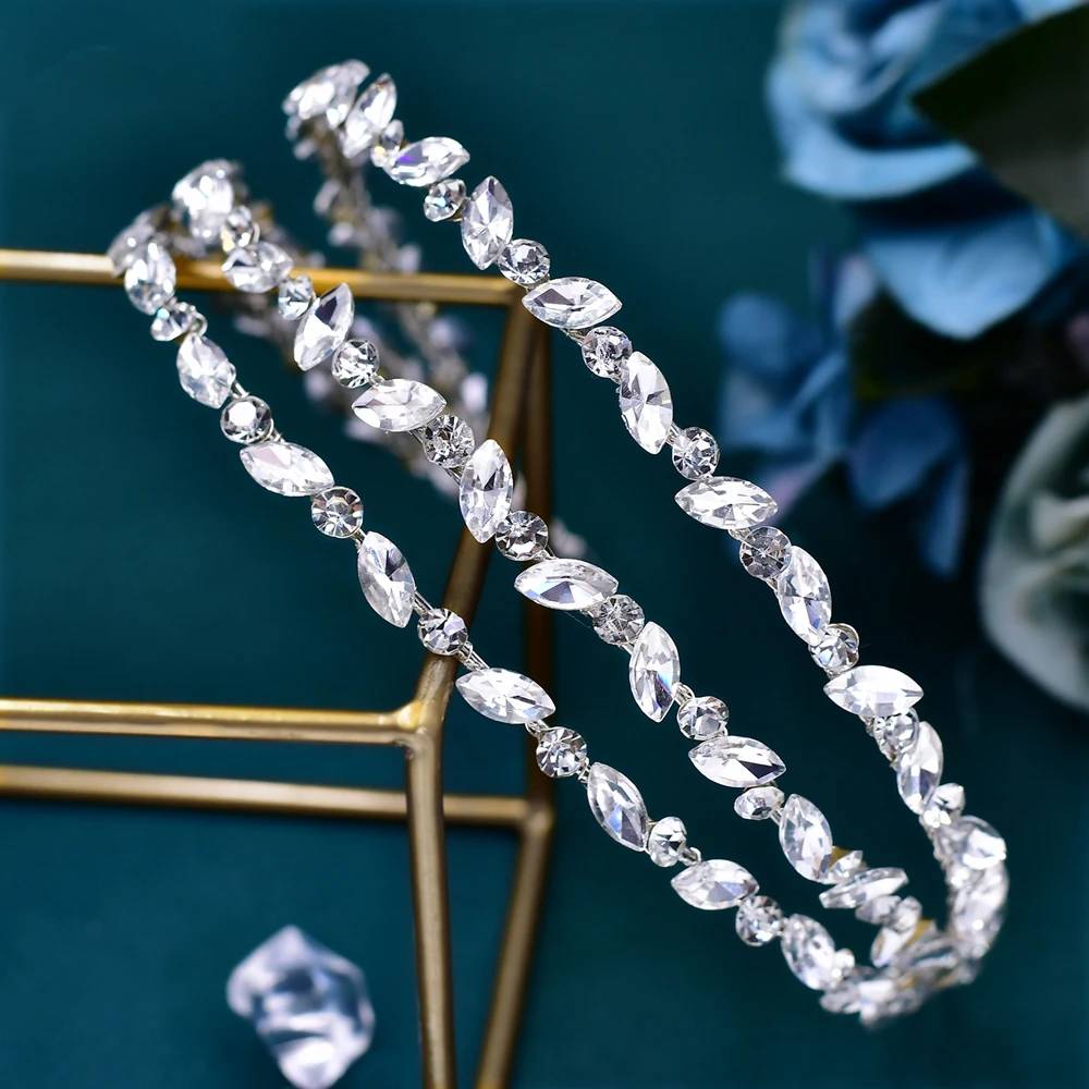 Side view of a silver rhinestone bridal headband showcasing alternating leaf and round crystal patterns.