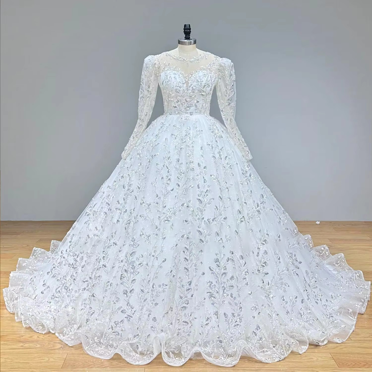 Close-up front view focusing on the exquisite crystal beading, silver embroidery, and high-shine sequins on the structured off-shoulder sweetheart bodice of the bridal gown.