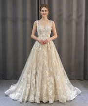 Front view of a romantic A-line beach style wedding dress with lace floral detailing on a model.