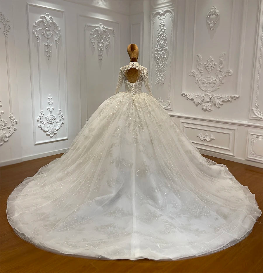 Rear view of a romantic high neck lace wedding gown on a mannequin, showcasing the elegant illusion keyhole back design, lace-up corset, and majestic, sprawling cathedral train.