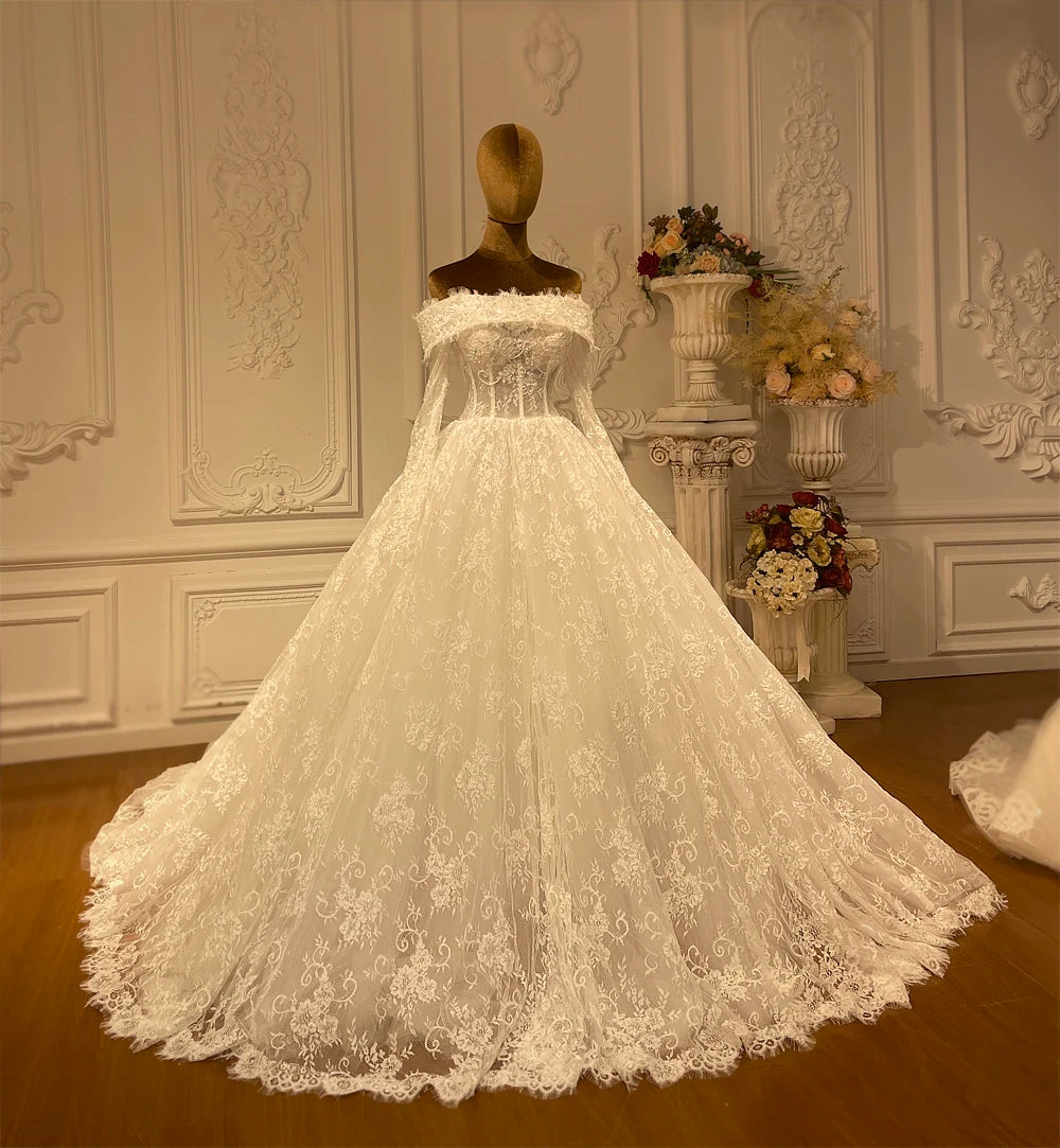 Back view of an elegant A-line wedding dress showcasing an expansive cathedral-length lace train and delicate shoulder detailing.