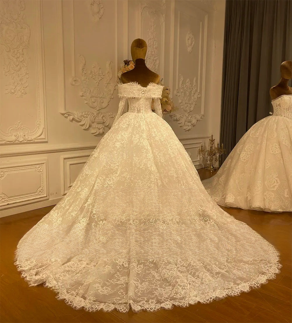 Back view of an elegant A-line wedding dress showcasing an expansive cathedral-length lace train and delicate shoulder detailing.