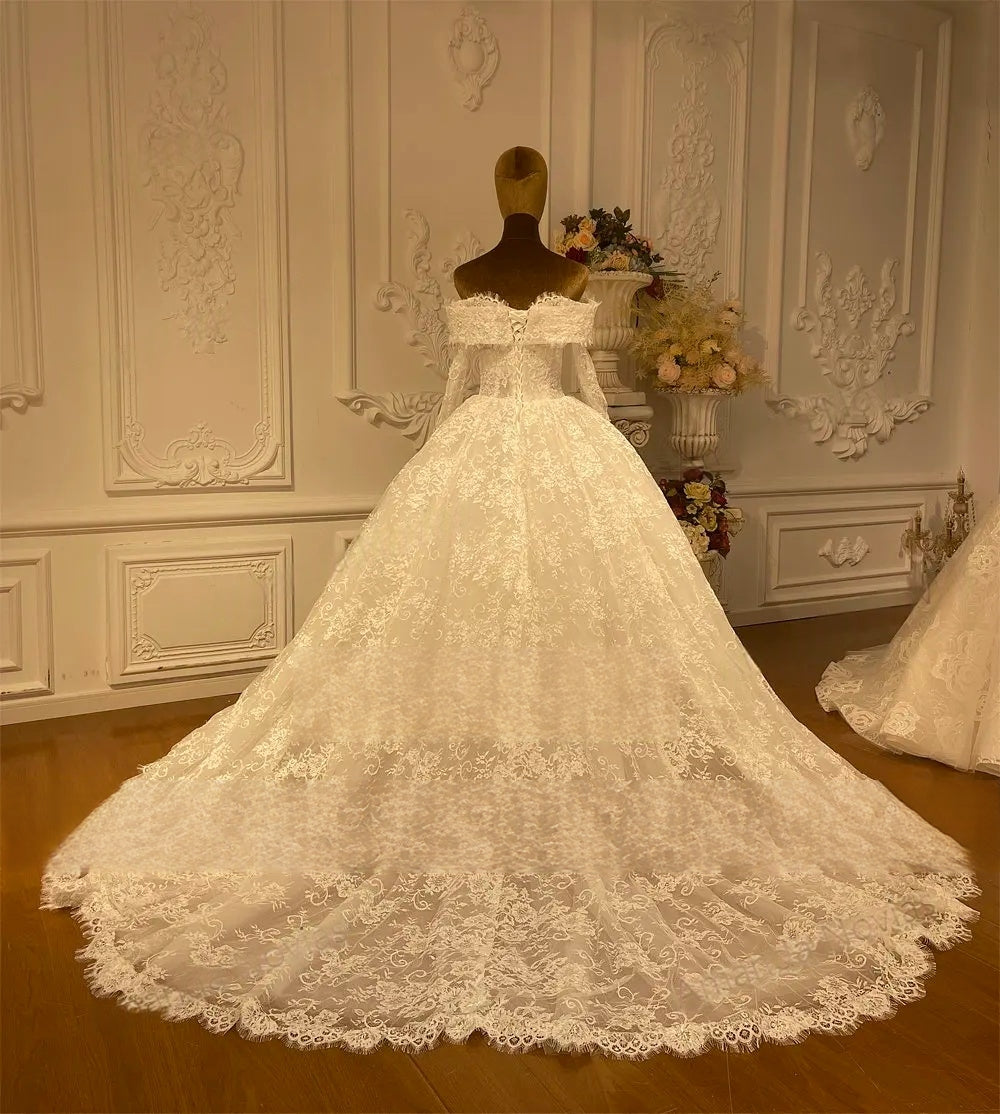 Rear view of a romantic off-the-shoulder bridal gown highlighting the intricate floral lace embroidery and structured back.