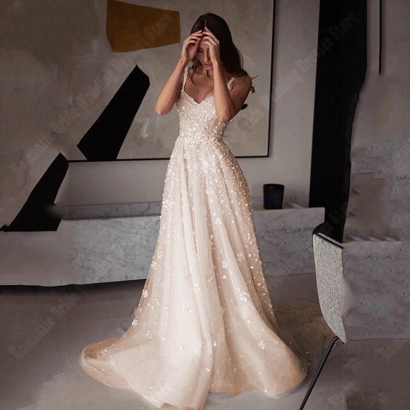 A side-profile view of a bride modeling this sleeveless princess-style bridal gown, emphasizing the delicate craftsmanship of the floral-appliqué tulle.