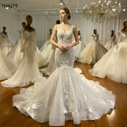 Front view of a model wearing a romantic mermaid wedding dress featuring floral lace straps, a fitted beaded bodice, and a voluminous flared tulle skirt in a luxury bridal showroom.