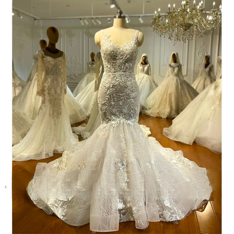 Silhouette of a fitted mermaid wedding dress with floral lace patterns and a dramatic flared tulle skirt displayed on a mannequin.