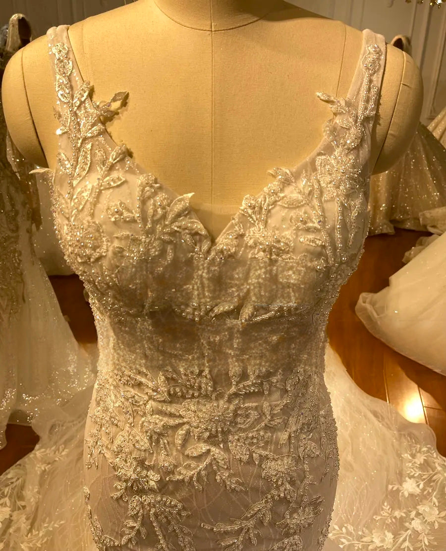 Macro shot of the beaded floral lace and sweetheart neckline on a luxury romantic straps mermaid wedding dress.