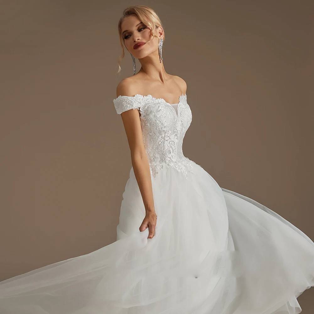 Model showcasing a dreamy long sleeve bridal gown featuring cascading 3D floral embroidery, a structured bodice, and a voluminous tiered tulle skirt.
