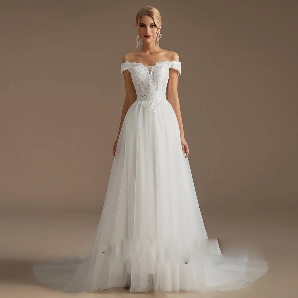 Detailed close-up of a wedding dress back, highlighting the elegant ribbon lace-up corset closure framed by sheer mesh and delicate 3D floral lace embroidery.