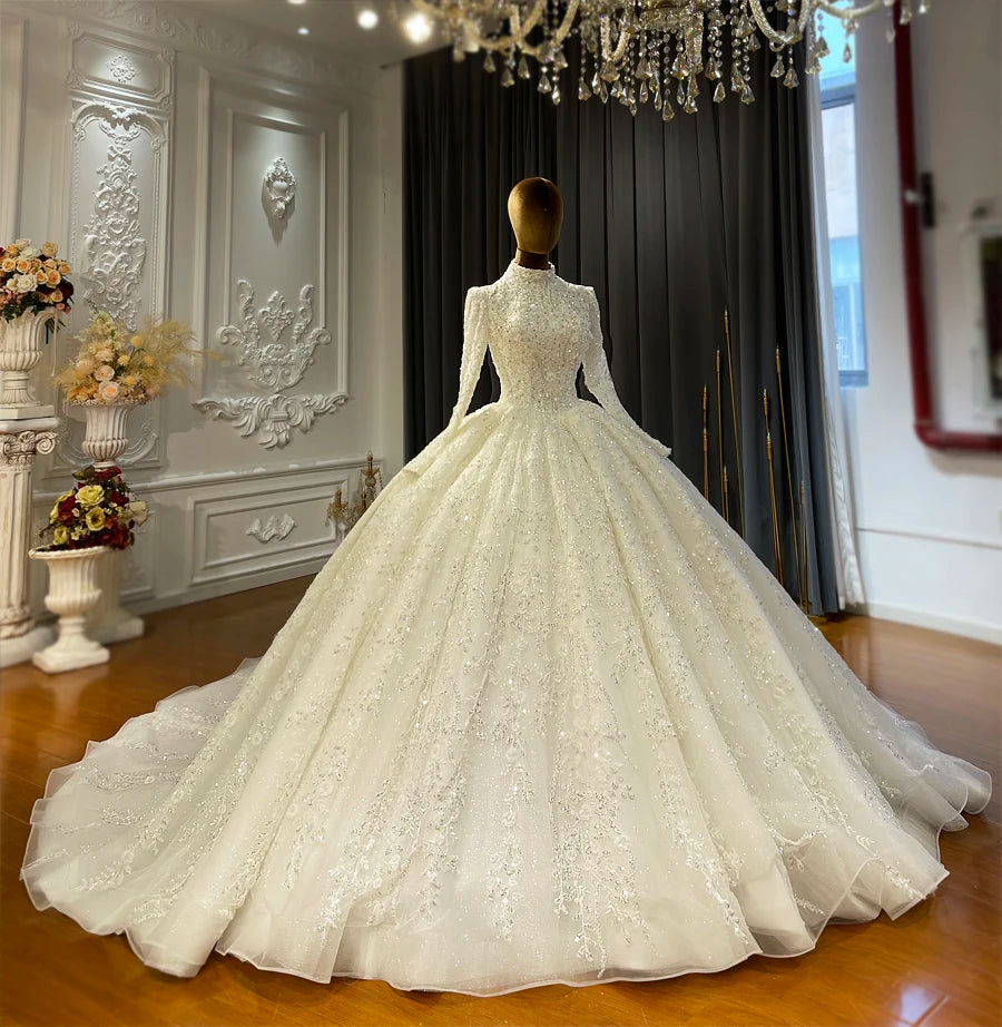 Front view of a royal Islamic wedding dress on a mannequin, showcasing the modest long-sleeve design, heavy handmade crystal embroidery, and majestic ball gown silhouette.