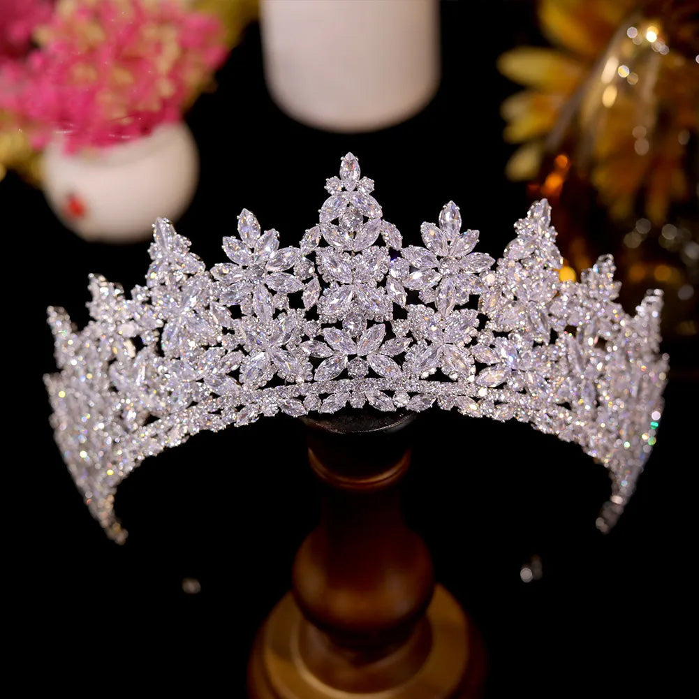 Product view of an open-back silver bridal party tiara headband featuring a large central teardrop crystal accented by staggered pave rhinestone rows.
