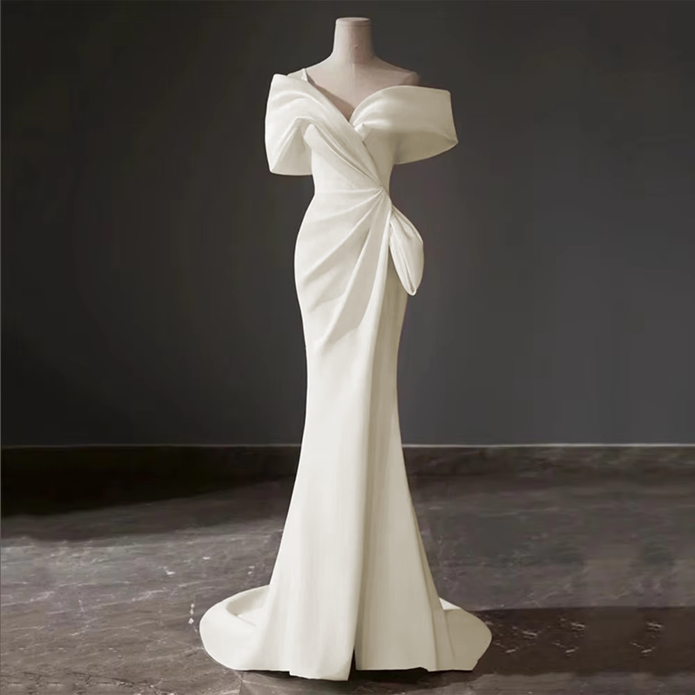 Detailed view of an editorial bride wearing a structured off-shoulder satin gown and a delicate birdcage face veil.