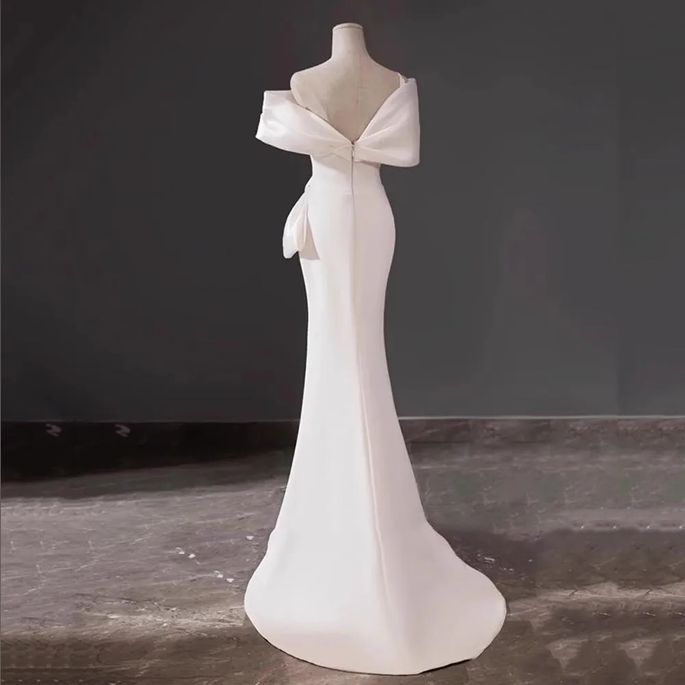 Non-traditional pale lavender silk-satin bridal gown with a structured sweetheart portrait neckline and an elegant high leg slit.