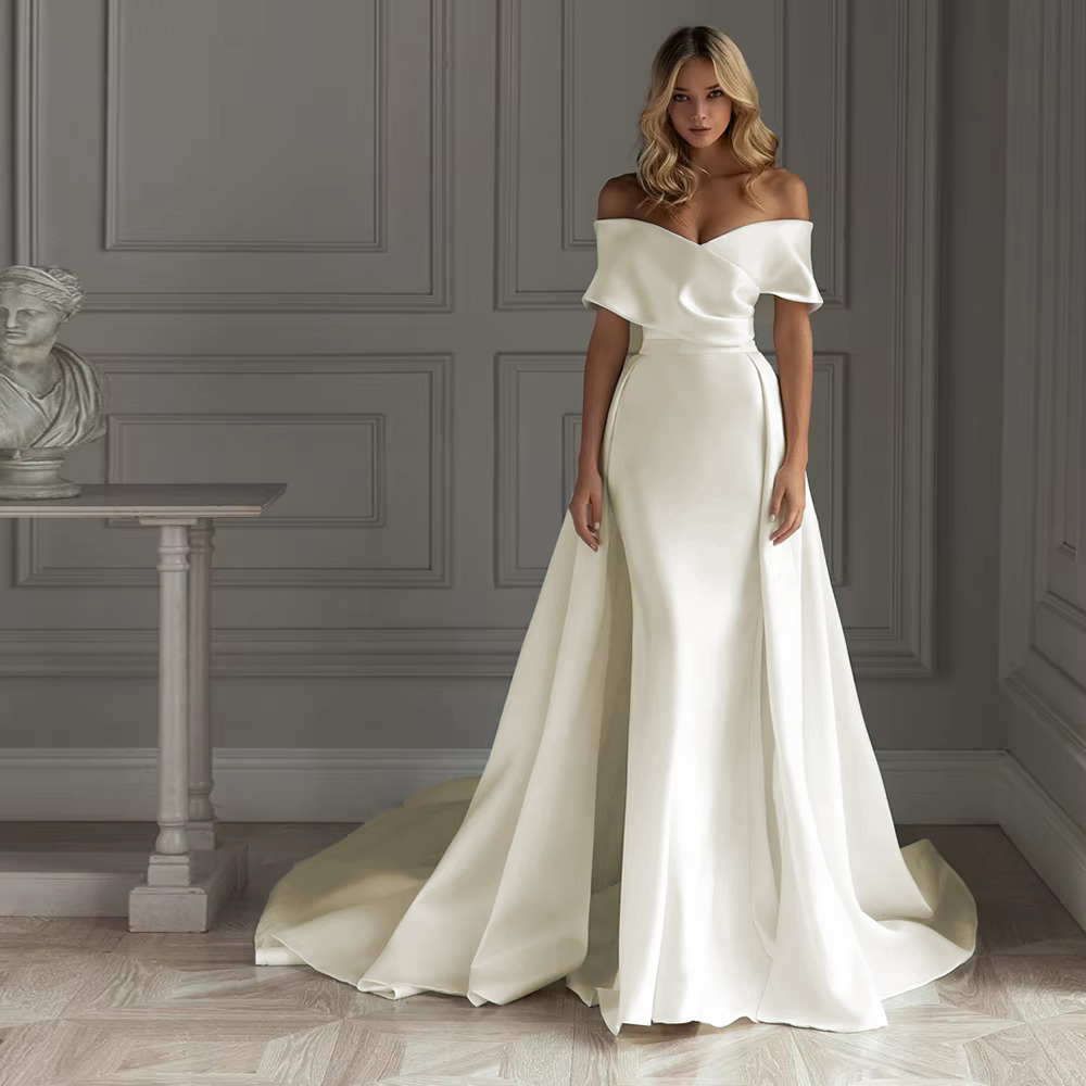 Stately pure white structural satin bridal gown with an asymmetric draped off-the-shoulder neckline, a seamless trumpet profile, and a sweeping white train extensions.