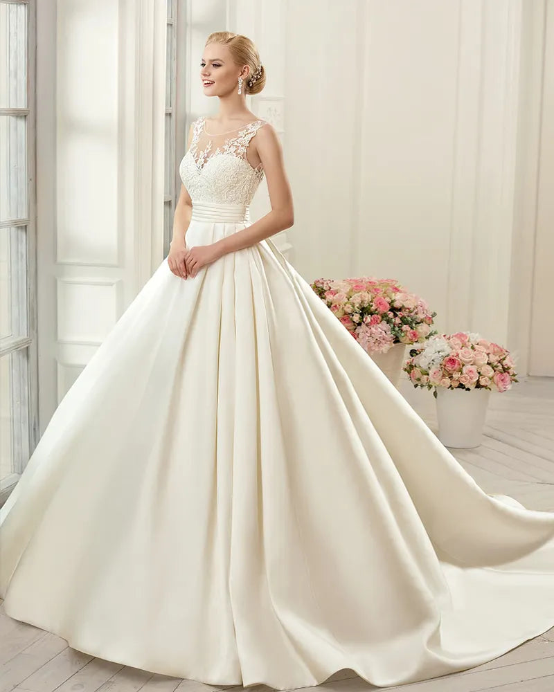 Simple A-line bridal dress featuring a clean satin skirt, sweetheart neckline, and elegant lace applique bodice detail.