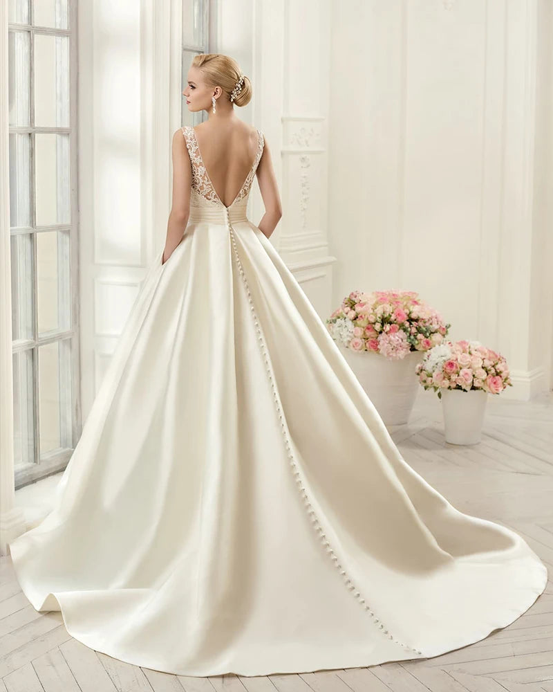 Back view of a simple satin A-line wedding dress with a sexy backless design and classic button closure details.
