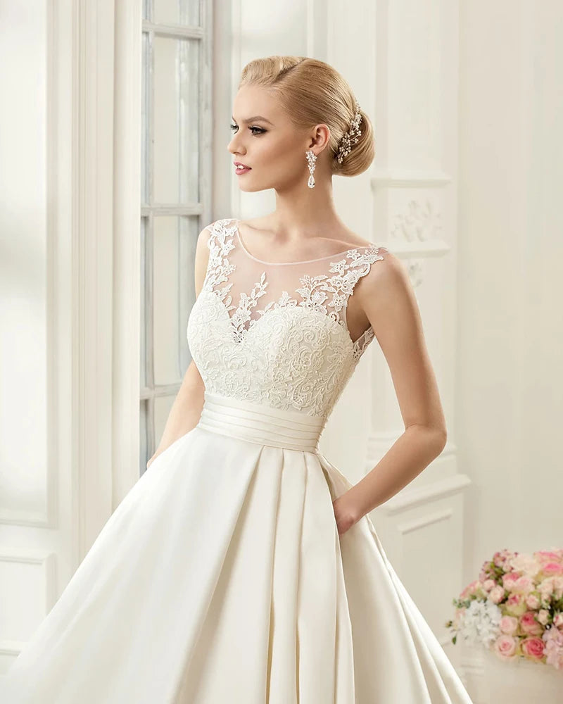 Close-up front view of an elegant satin A-line bridal gown, showcasing the sweetheart neckline and intricate lace applique bodice.