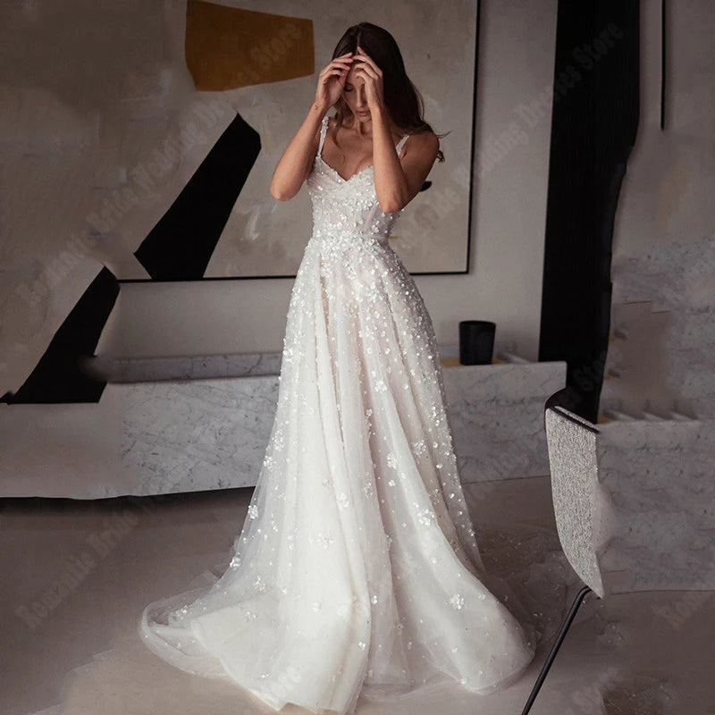A bride showcasing the princess-style silhouette of this sleeveless tulle bridal gown, highlighting its romantic floral-embellished bodice and graceful A-line cut.