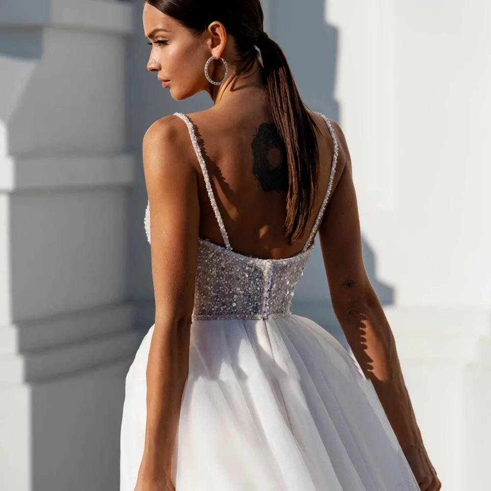 Detailed close-up of an intricate sweetheart wedding dress bodice embellished with luxury silver sequins, crystals, and sheer illusion side cutouts.