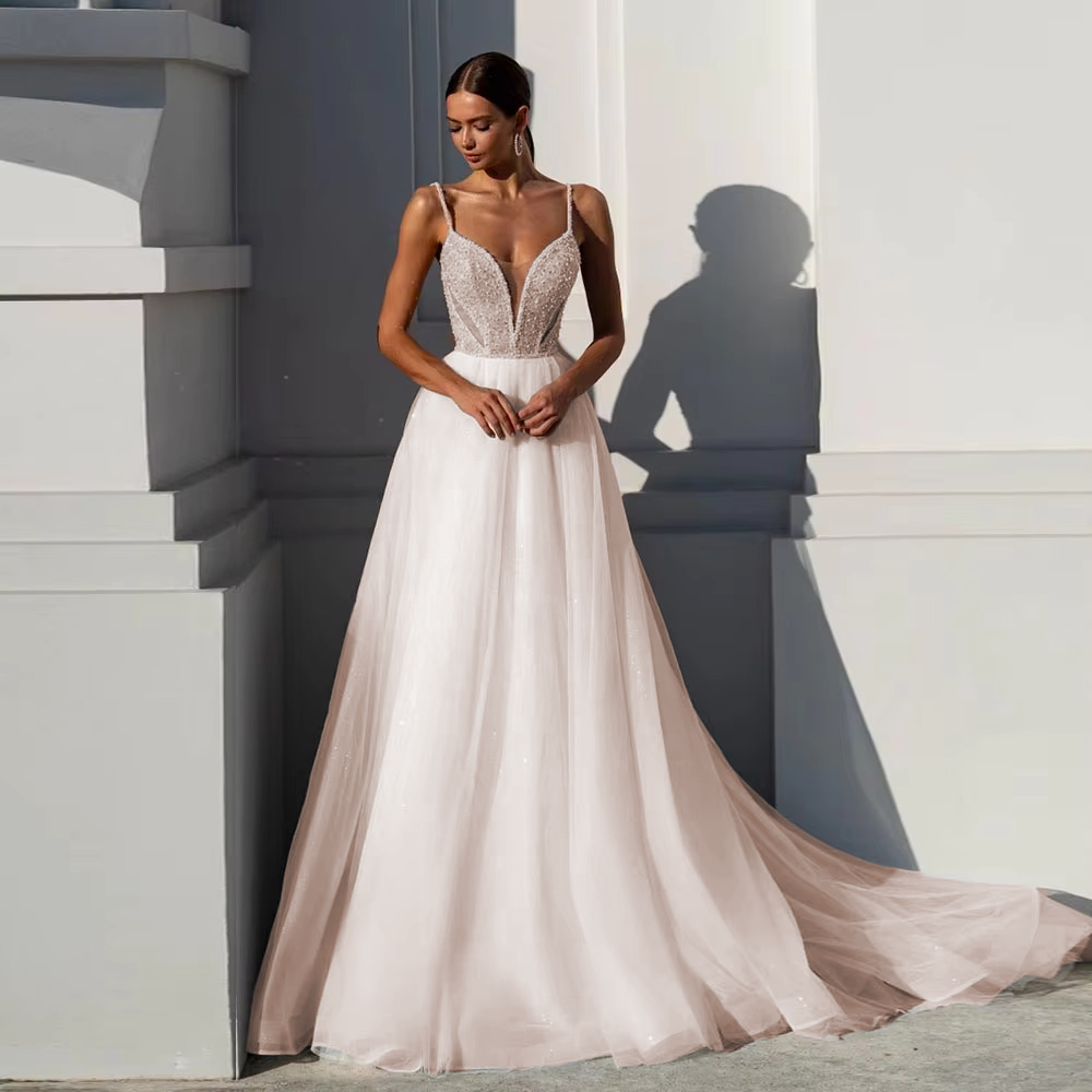 Romantic blush pink underlay wedding dress with a shimmering silver sequined bodice and an ethereal layered tulle A-line skirt.