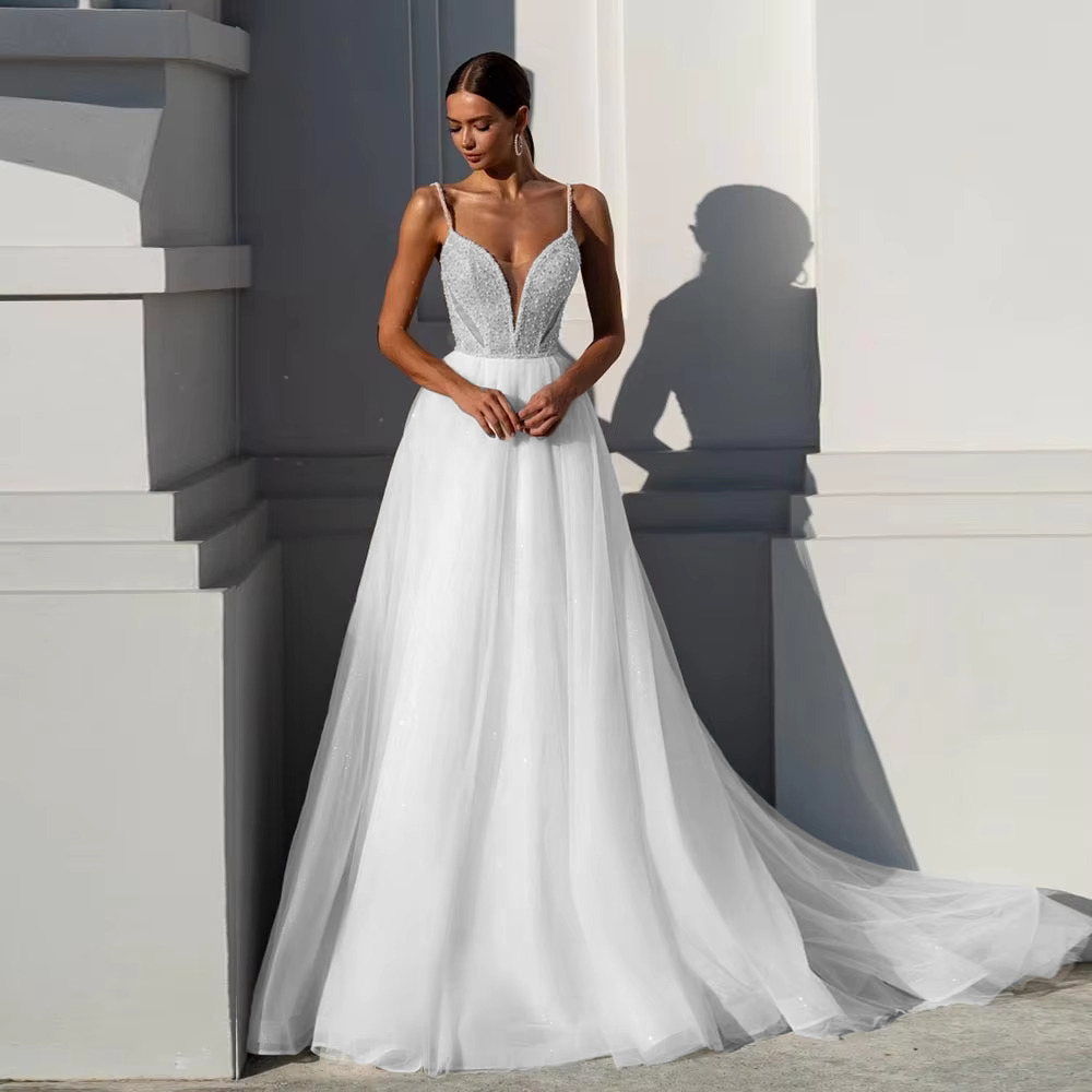 Stately pure white sparkly wedding gown with an embellished crystal bodice and a clean, luminous tulle skirt for a traditional bridal look.