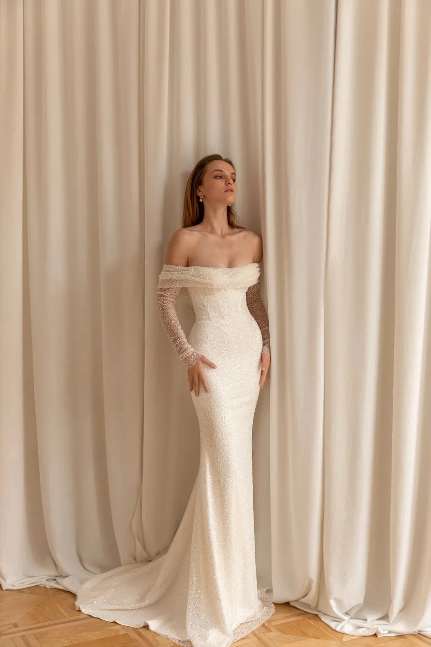 Front view of a sequined mermaid wedding dress with an off-shoulder neckline and long sleeves, elegant and form-fitting.