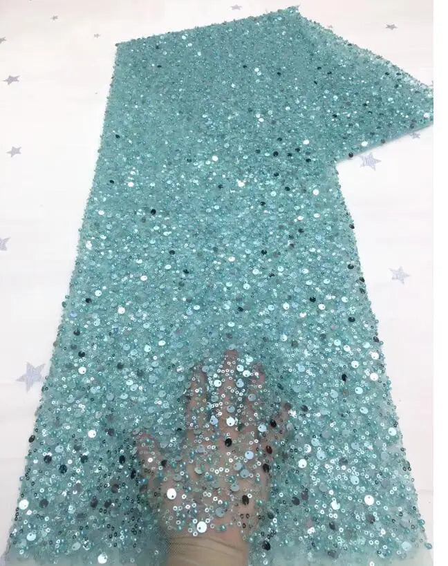 A bride wearing a glamorous off-shoulder mermaid wedding dress with long sequined sleeves and a flowing detachable train.