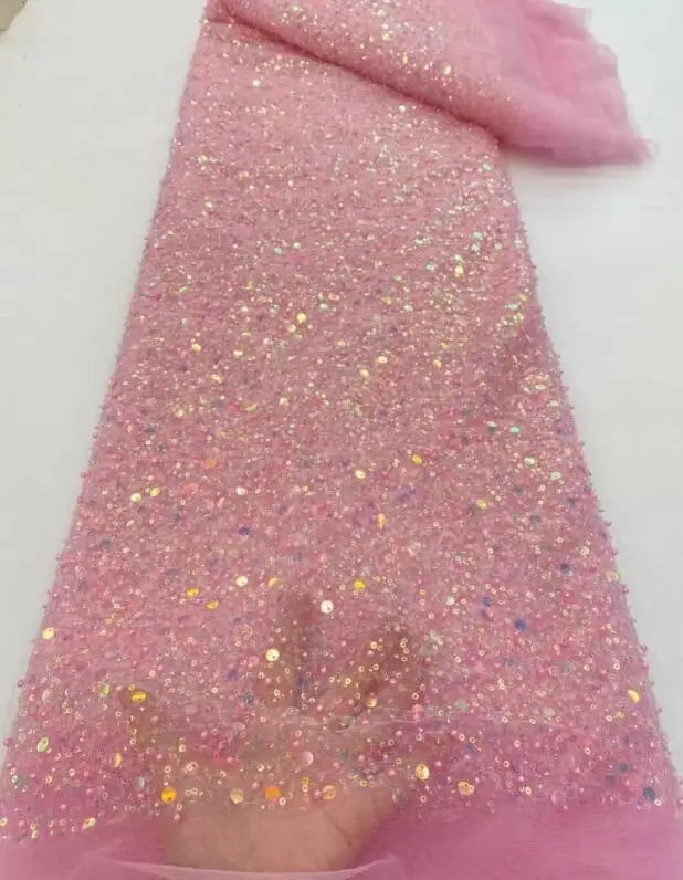 A detail shot of a bride posing in a sequined mermaid bridal gown with elegant off-shoulder styling and shimmering sleeve embroidery.
