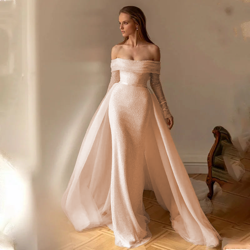 A final elegant pose of a bride in a sparkling off-shoulder mermaid wedding gown, highlighting the modern, sophisticated bridal aesthetic.