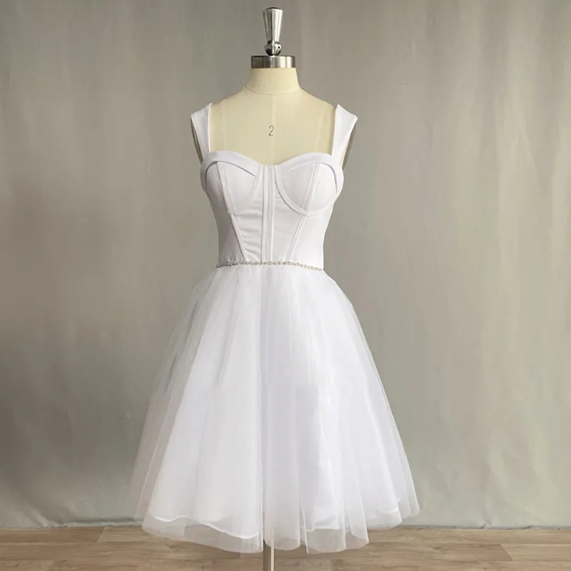 Front view of a pure white short A-line wedding dress on a mannequin showcasing a boned sweetheart bustier corset and a layered knee-length tulle skirt.