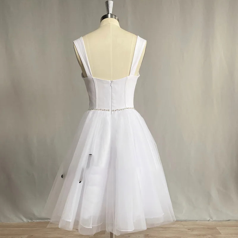 Back view of a short white wedding reception dress on a mannequin showing a square low back with a zipper closure and a thin beaded waist strip.