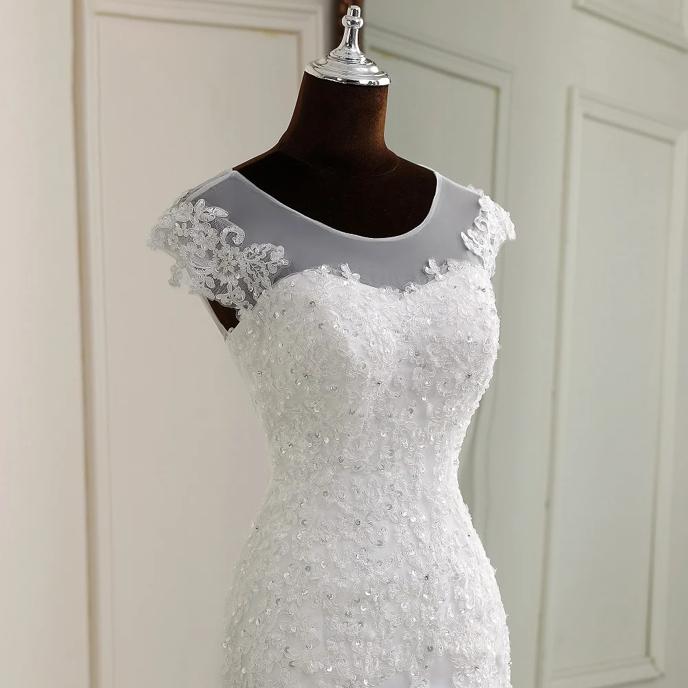 A mannequin displaying the front silhouette of an elegant, cap-sleeve mermaid wedding dress with lace embroidery.