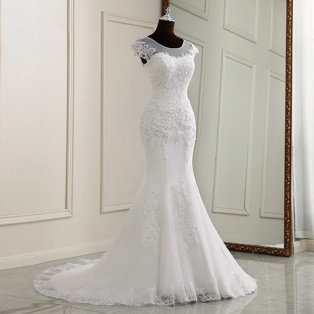 Rear view of the cap-sleeve mermaid wedding dress on a mannequin, highlighting the lace-up corset back and lace appliques.