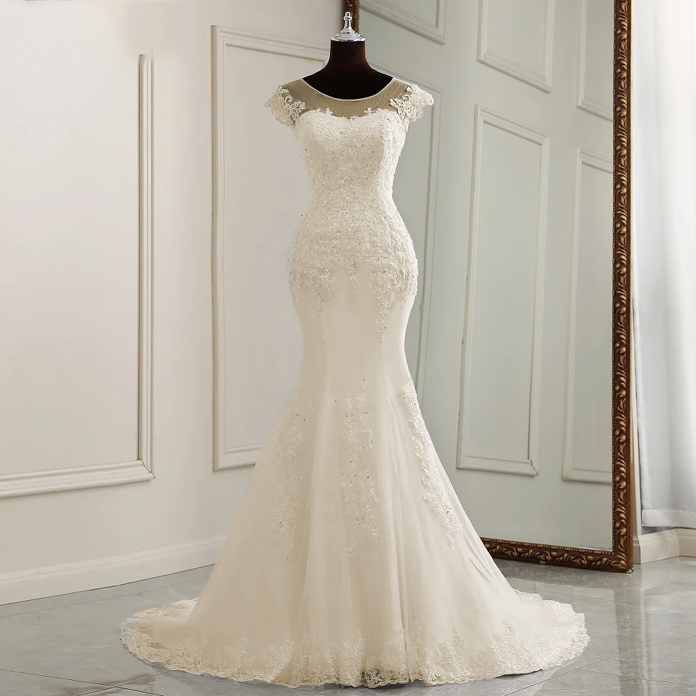 A mannequin display of the complete cap-sleeve mermaid bridal gown, showing the form-fitting silhouette and refined lace placement.