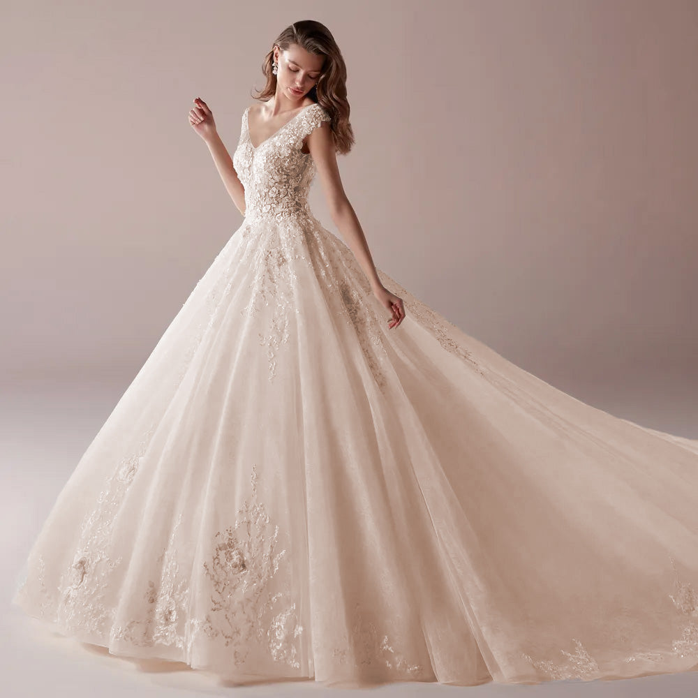 A side-view profile of a model in a sophisticated A-line wedding dress, focusing on the lace-detailed bodice, cap sleeves, and full A-line skirt.