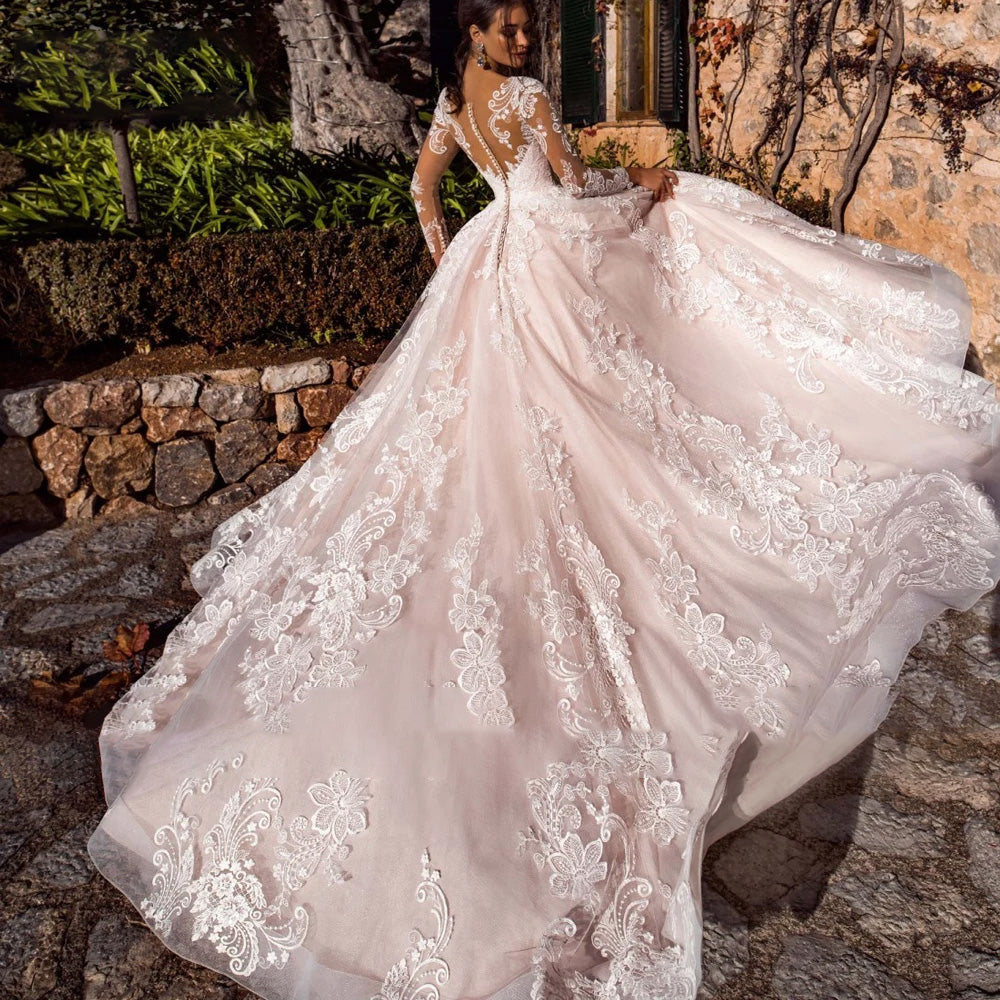 Back view of an A-line bridal gown with a dramatic court train, illusion back with delicate buttons, and exquisite lace detailing.