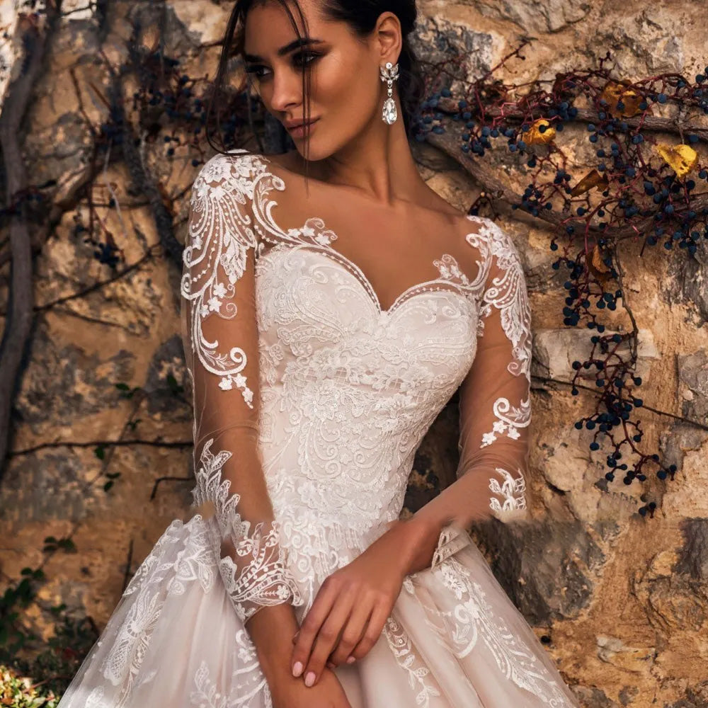 Close-up of the long sleeve illusion lace bodice, showcasing the intricate appliques and elegant scoop neckline of the vintage bridal gown.