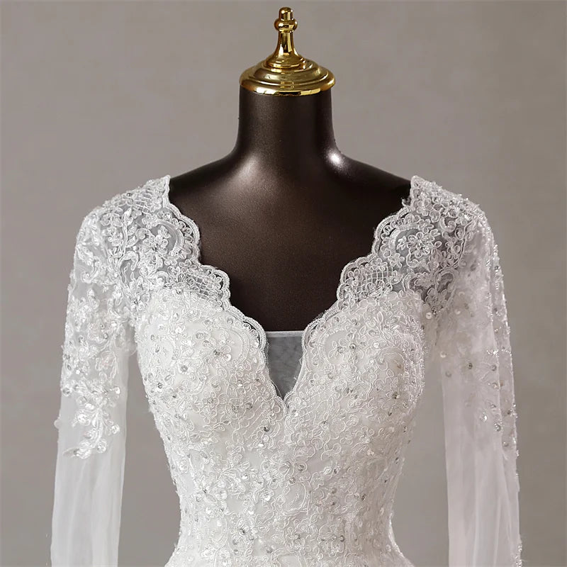 A detailed close-up of the delicate lace craftsmanship and embroidery on the long sleeves of the wedding dress.