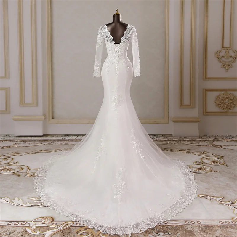 Side profile view of a long-sleeved mermaid wedding dress on a mannequin, showcasing the fitted silhouette and elegant lace appliques.