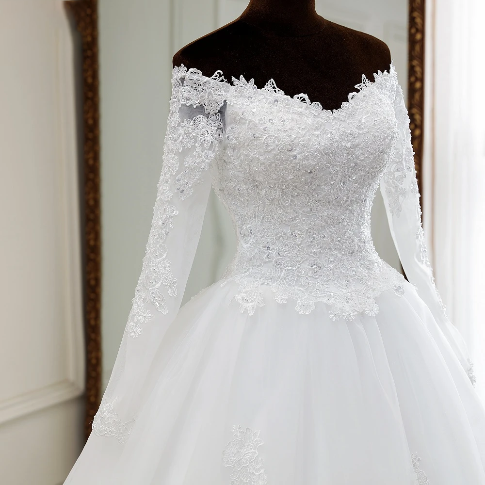 A mannequin showcasing a luxury long-sleeve, off-shoulder lace wedding gown with intricate floral lace appliques.