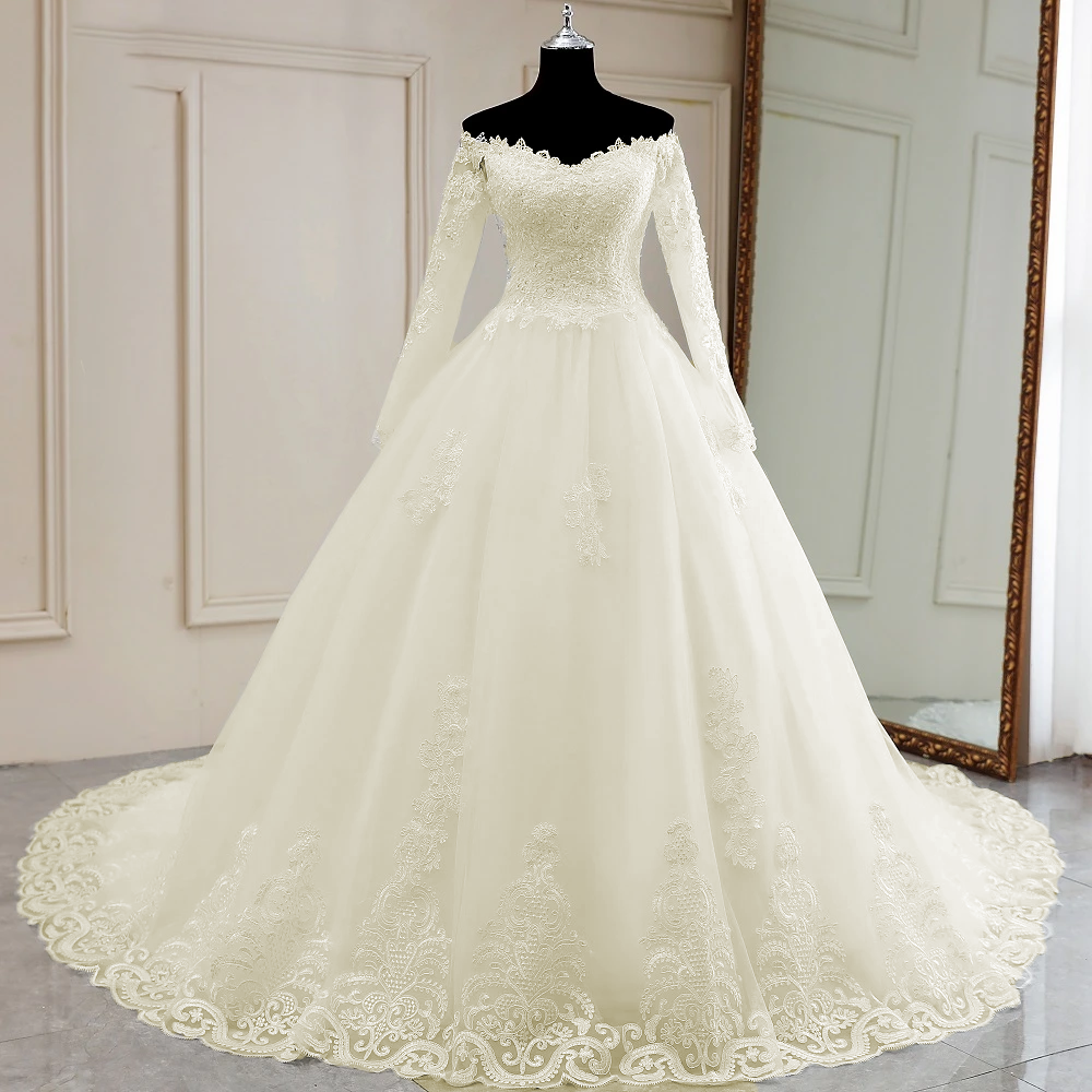 A mannequin showcasing the front view of a luxury, long-sleeve, off-shoulder lace wedding dress with a full, flowing bridal skirt.