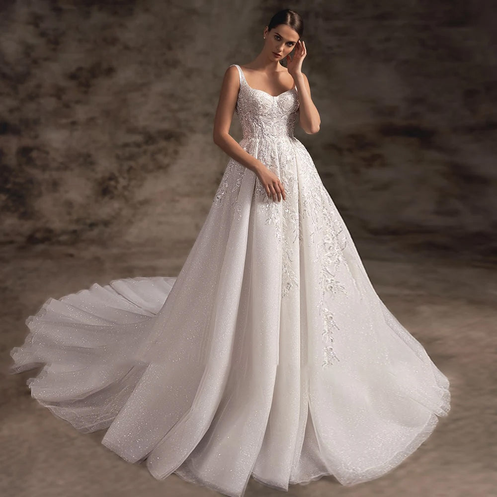Front view of a sophisticated spaghetti strap A-line wedding dress with a high slit and romantic court train.