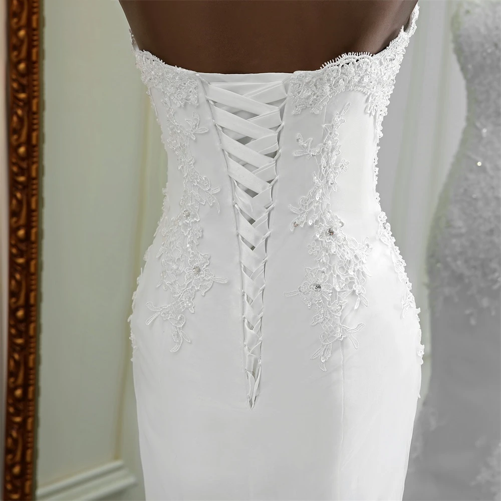 Rear view of a wedding dress featuring a corset-style lace-up back design and intricate beadwork.