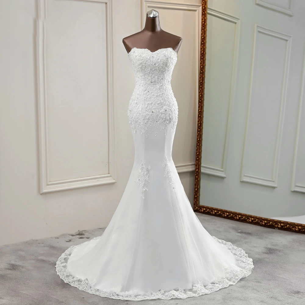 Mannequin display of a white strapless mermaid bridal gown with sophisticated lace placement.
